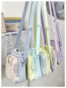 Detail view of colorful pastel crossbody phone bags hanging, showing multi-color design.