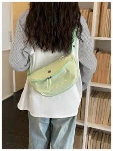 Lightweight nylon crescent sling bag detail, casual crossbody style in light green color.