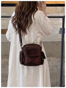 Vue détaillée du sac bandoulière décontracté marron à poches multiples, pratique et chic.
