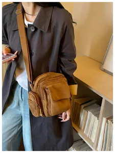 Vue détaillée d'un sac bandoulière décontracté marron rétro à poches multiples et sangle.