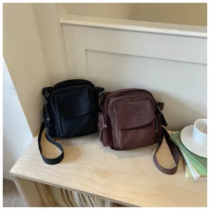 Vue rapprochée de sacs bandoulière décontractés en toile avec poches sur une étagère en bois.