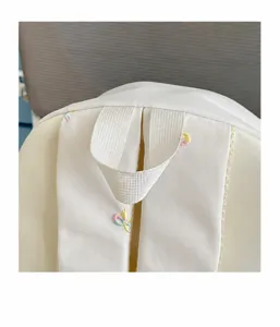 Student school backpack top handle detail in white with cute colorful bow embroidery