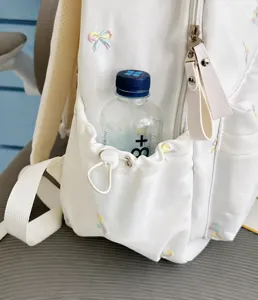 White student schoolbag with cute bow embroidery, featuring a convenient side pocket design.