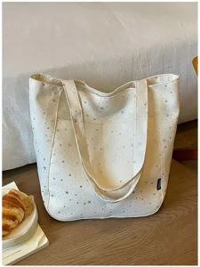 Canvas tote bag detail featuring silver star print, double straps and front pocket.