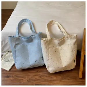 Detailed view of the casual canvas tote bag with star print, featuring front pocket design.