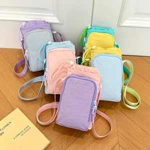 Detail view of lightweight color-block water bottle bag and phone messenger bag for outdoor travel.