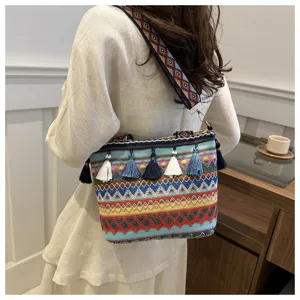 Detailaufnahme der bunten gewebten ethnischen Schultertasche mit Quasten und Riemen.