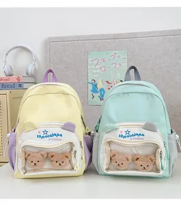 Mochila escolar pastel bonita con bolsillo frontal transparente y adorables colgantes de peluche.