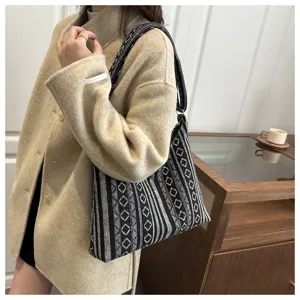 Ethnic geometric canvas shoulder bag detail view with black and white patterned underarm design.