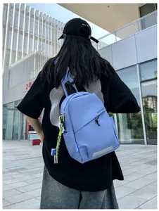 Vue de détail en extérieur montrant un sac de poitrine bleu clair porté sur le dos.