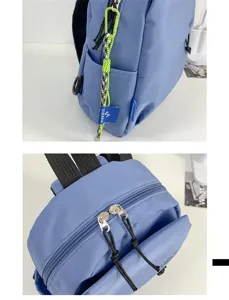 Vue détaillée du sac à dos bleu montrant la fermeture éclair solide et la poche latérale.