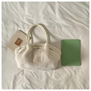 Primo piano della borsa a tracolla in morbida peluche bianca con dettagli raffinati.