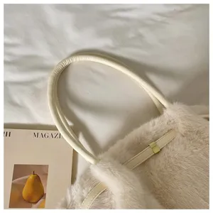 Dettaglio in primo piano della borsa a spalla in eco-pelliccia soffice con cinturino in pelle.