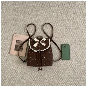 Brown polka dot mini backpack detail, featuring cute white lace trim and bow decoration.