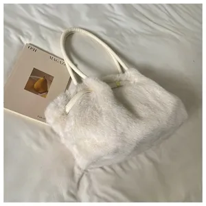 Dettaglio della borsa a spalla in peluche bianco, morbida ecopelliccia con cinturino in pelle.