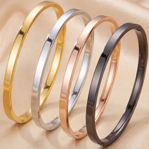 Closeup of minimalist smooth metal bangles in four shiny colors, fine jewelry detail shot.