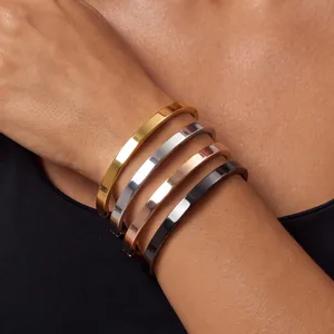 Minimalist stainless steel bracelet detail showing four polished multi-color bangles on wrist.