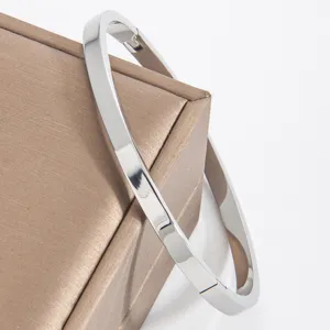Minimalist smooth stainless steel metal bangle bracelet detail view with polished finish.