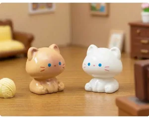 Gros plan de mignons petits chats assis miniatures, parfaits pour la déco de bureau et de paysage.