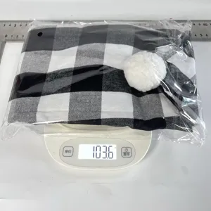 Detailed view of black and white plaid chair cover in packaging on scale showing weight.