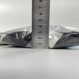 Detailed view showing the thickness of the plaid chair cover packaged in clear bag.