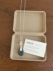 Detailed view of the elegant natural stone teardrop necklace with delicate silver chain in box.