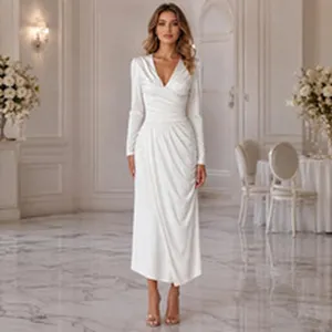 Elegant white long-sleeve midi dress detail shot in a luxurious classical interior setting.