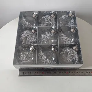 Detailansicht von 9 transparenten Christbaumkugeln gefüllt mit silberem Glitzer und Perlen.