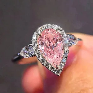 Dettaglio dell'anello in zircone rosa taglio a pera con pietre di pavé e gemme laterali.