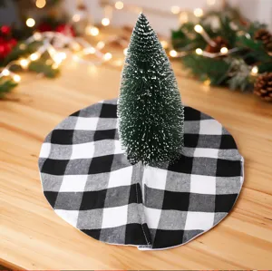 Detailed shot of a mini Christmas tree on a black and white buffalo plaid tree skirt.