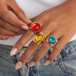Detailed close-up view of retro chunky gold rings featuring vibrant red, yellow and blue gems.
