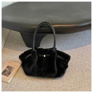 Dettaglio della borsa a spalla in peluche nero con morbida pelliccia sintetica e manici in pelle.