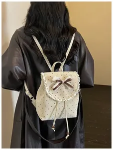 Backpack detail showing sweet polka dot pattern, delicate lace trim and cute bow decoration.