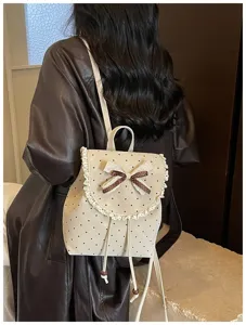 Detail view of the cute polka dot backpack featuring lace trim, cute bowknot, and straps.
