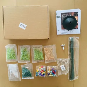 Kit d'arbre de Noël en perles DIY vue de détail, rocailles en verre colorées, guirlande et fil.