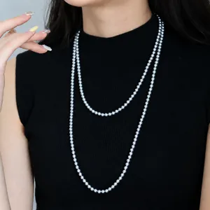 Vue détaillée de l'élégant long collier de perles à double rang, avec des perles et texture.