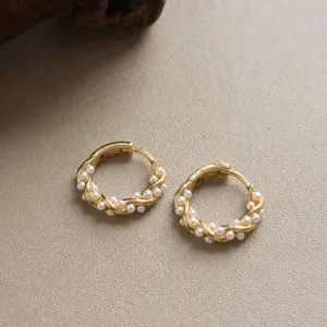 Exquises boucles d'oreilles créoles en perles dorées pour femmes, détail bijou torsadé.