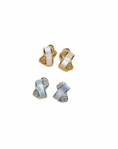 Vue détaillée de boucles d'oreilles croisées en nacre et zircone aux belles finitions.