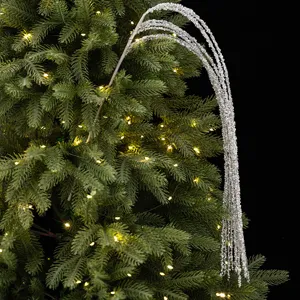 Vue détaillée d'une branche scintillante argentée pour sapin de Noël, texture de franges fines.