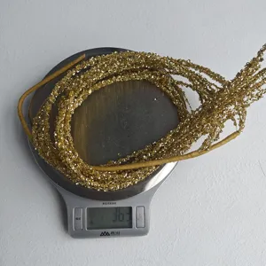 Gros plan de pompon paillete dore, ideal pour la decoration de sapin de Noel et fetes de fin d annee.