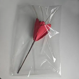 Detailed view of red fabric Christmas artificial flower stem with golden glitter decor.