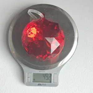 Red faceted acrylic Christmas ornament hanging pendant shown on scale weighing 49.2g.