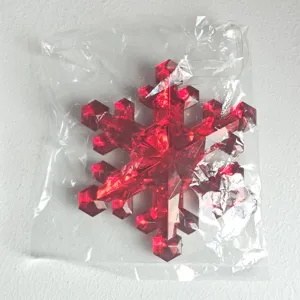 Red acrylic snowflake Christmas tree ornament, sparkling hanging decoration in clear bag.