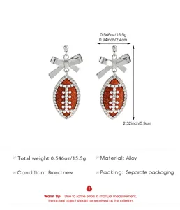 Silver tone alloy football and bow drop earrings with crystal and pearl details, 2.32 inch.