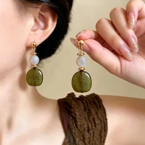 Retro acrylic long earrings detail showcasing green marbled resin beads and gold-tone studs.