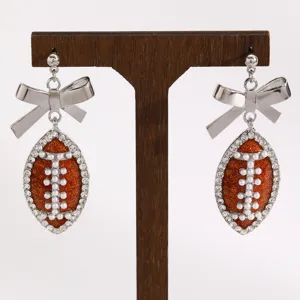 Trendy football bow earrings with rhinestones and pearls, perfect for sports fans.