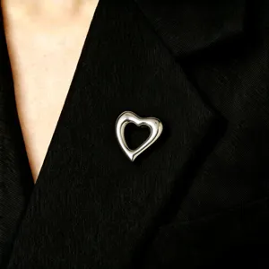Close-up of a sleek stainless steel heart brooch, minimalist lapel pin design.