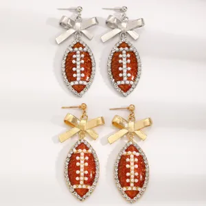 Stylish football bow earrings with rhinestones and pearls, perfect for sports fans game day.