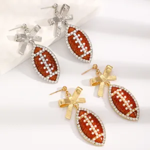 Detailed close-up of fashion sports football bow earrings featuring sparkling rhinestones and pearls.