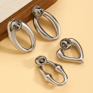 Silver metallic geometric brooch pins set, abstract design detail shot for elegant suit decor.